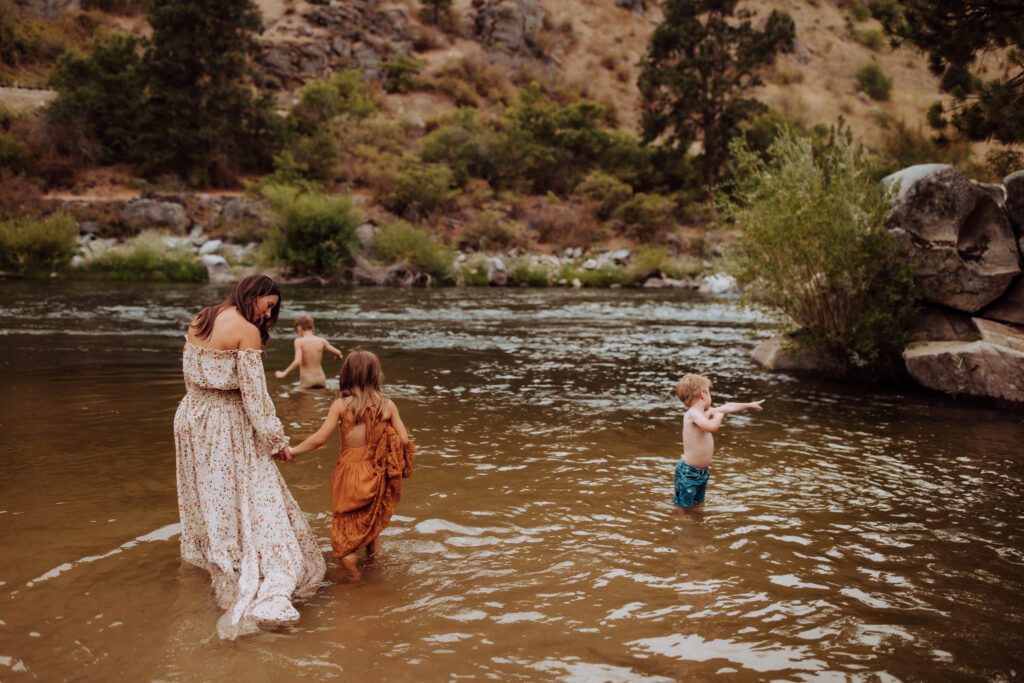 mom and three kids playing in the river outside boise idaho